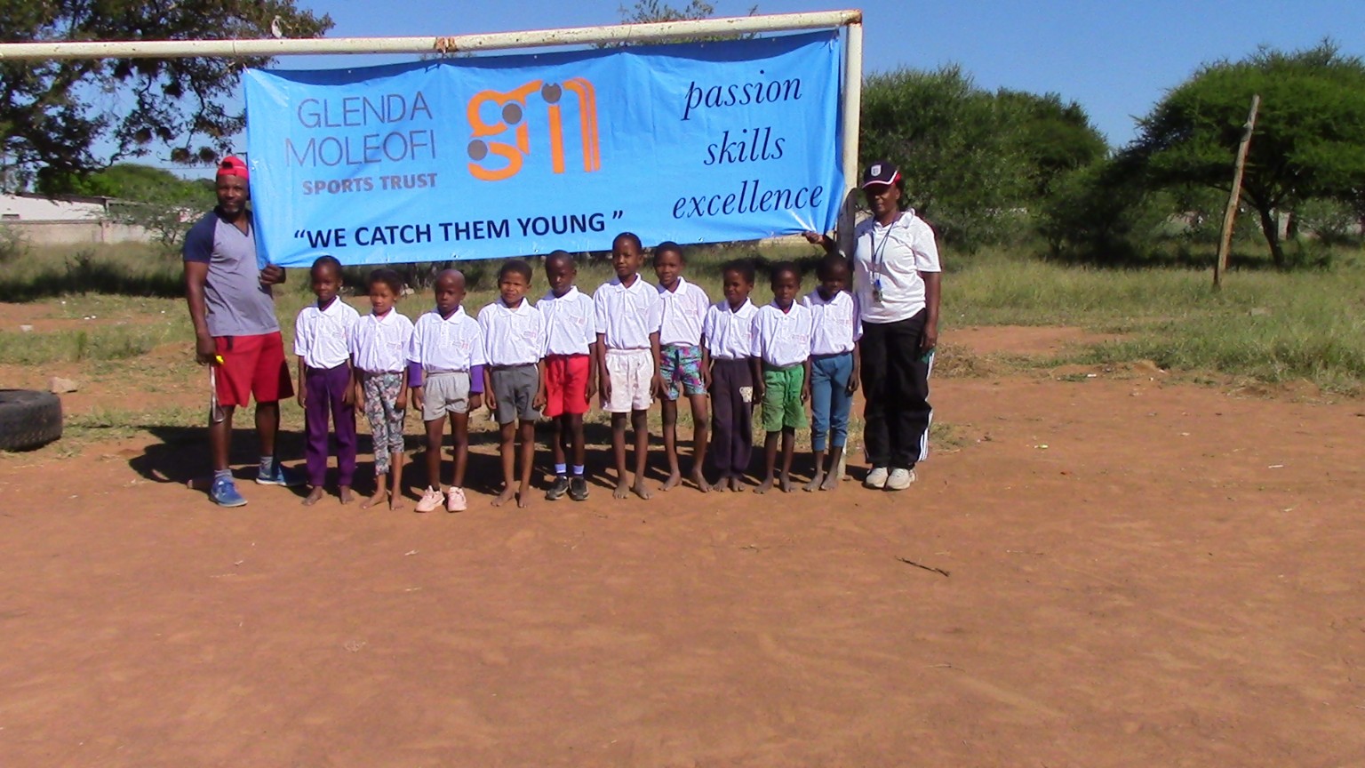 GMST youth participants and coaches beneath a Glenda Moleofi Sports Trust banner